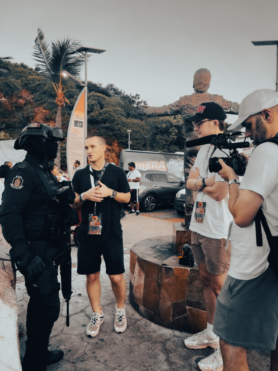 Camermen filming a younger man interviewing a person